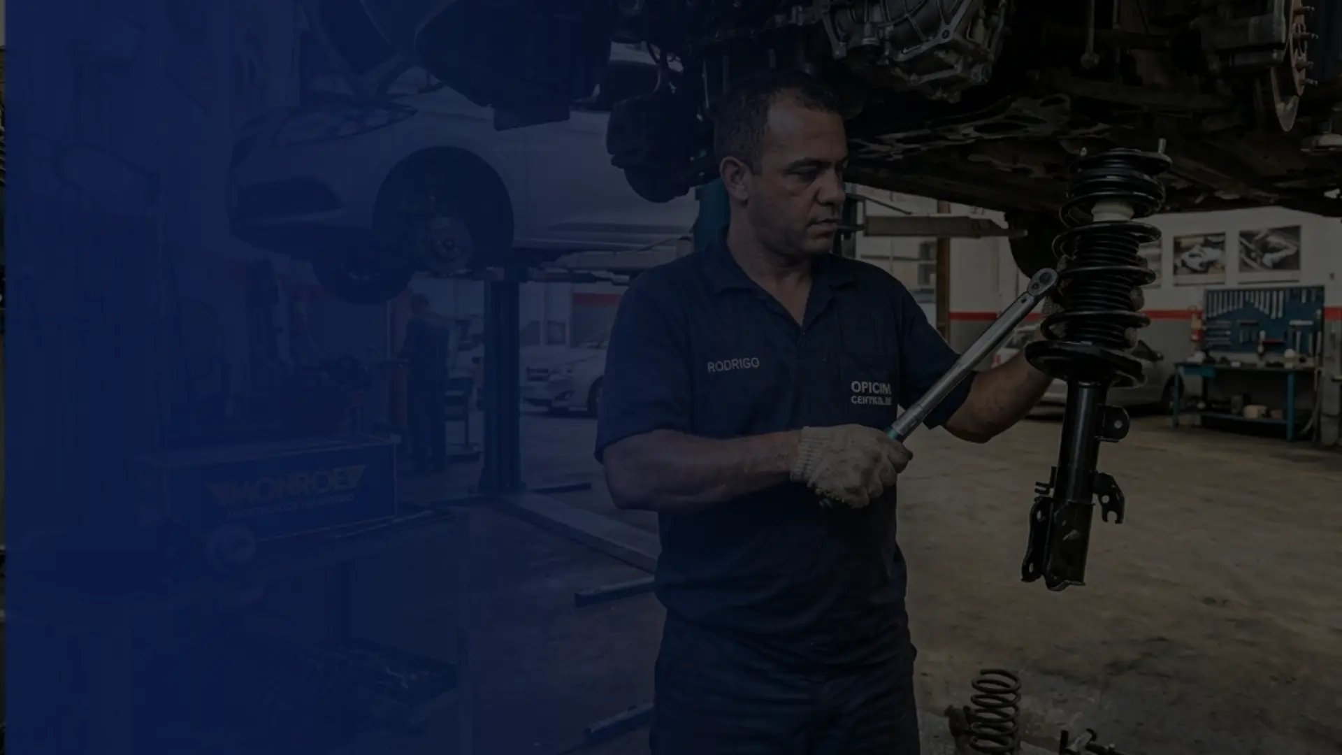 Veículo posicionado em elevador automotivo para revisão de sistema de suspensão.